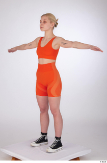 Unaisa dressed orange bike shorts orange sports bra standing t-pose…